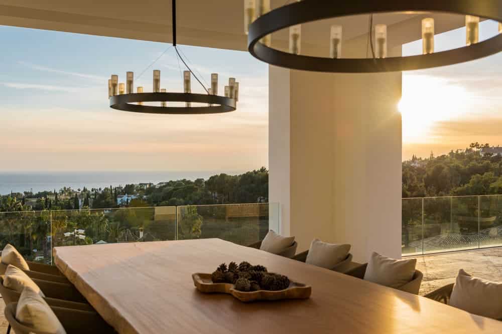 Contemporary villa terrace at dusk designed by ARK Architects in Cascada de Camoján, Marbella.