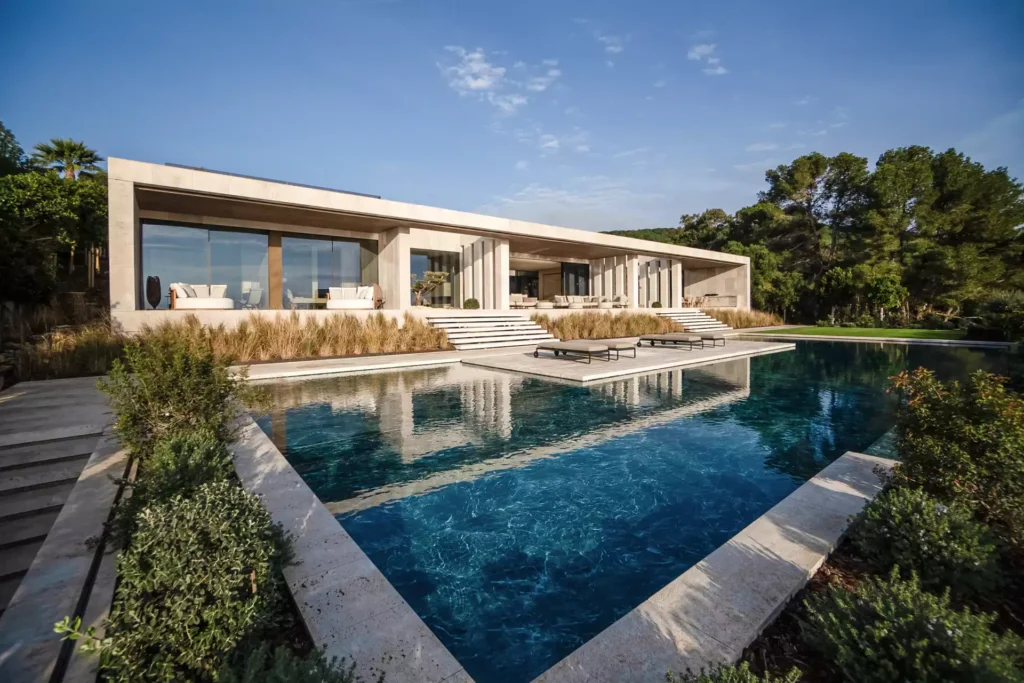 Contemporary exterior of Villa Tai in Sotogrande, featuring clean white volumes and warm integrated architectural lighting at dusk.