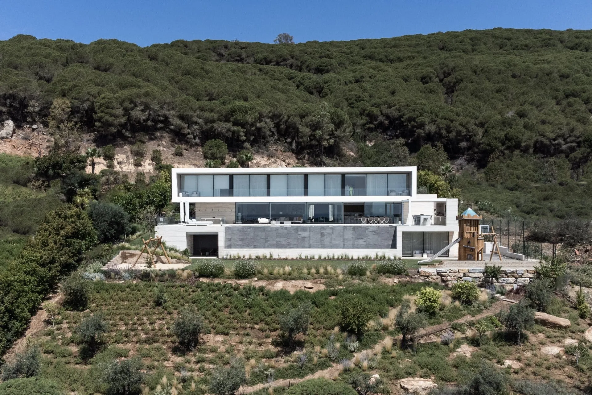 Majestic sunset view of Villa Frame's infinity pool and white geometric architecture designed by Manuel Ruiz Moriche in Sotogrande.