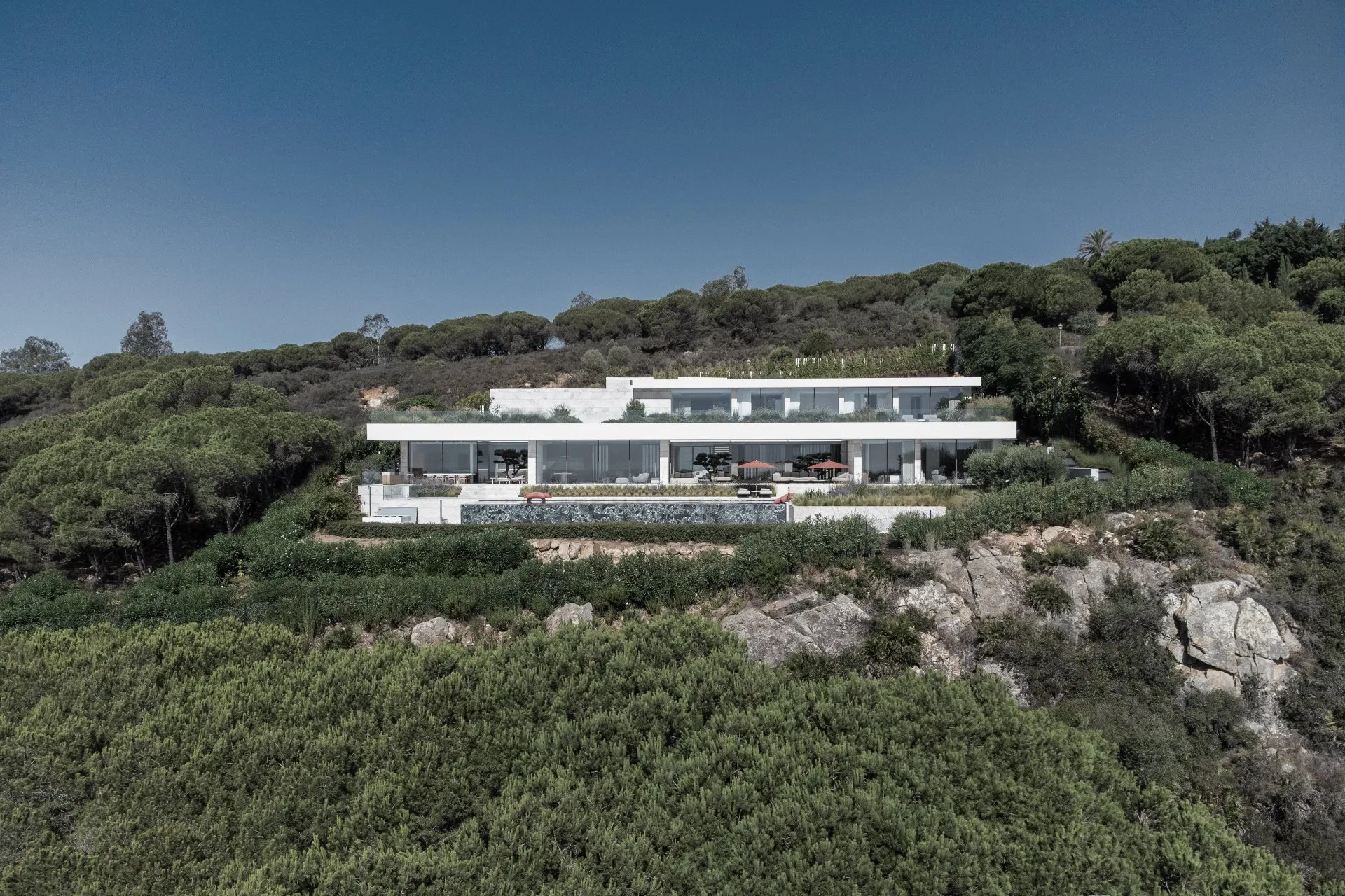 Panoramic view of a high-end residential project featuring minimalist lines and integration with the Mediterranean landscape.