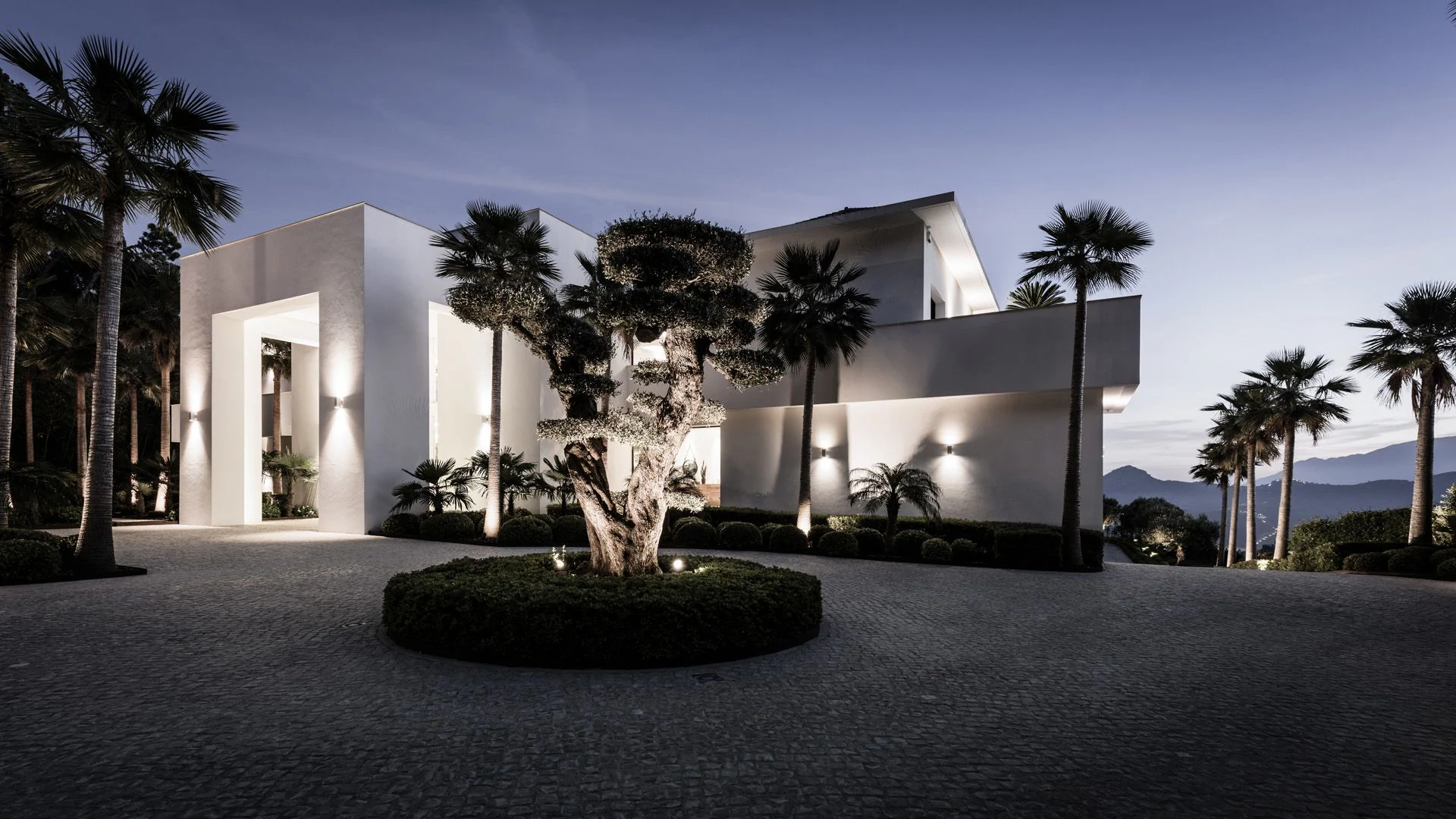 Contemporary white villa architecture featuring clean lines and manicured landscaping by ARK Architects.