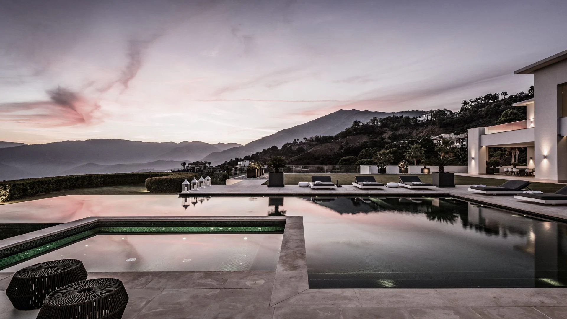 Minimalist poolside terrace overlooking the Mediterranean landscape and Sierra Blanca mountains.