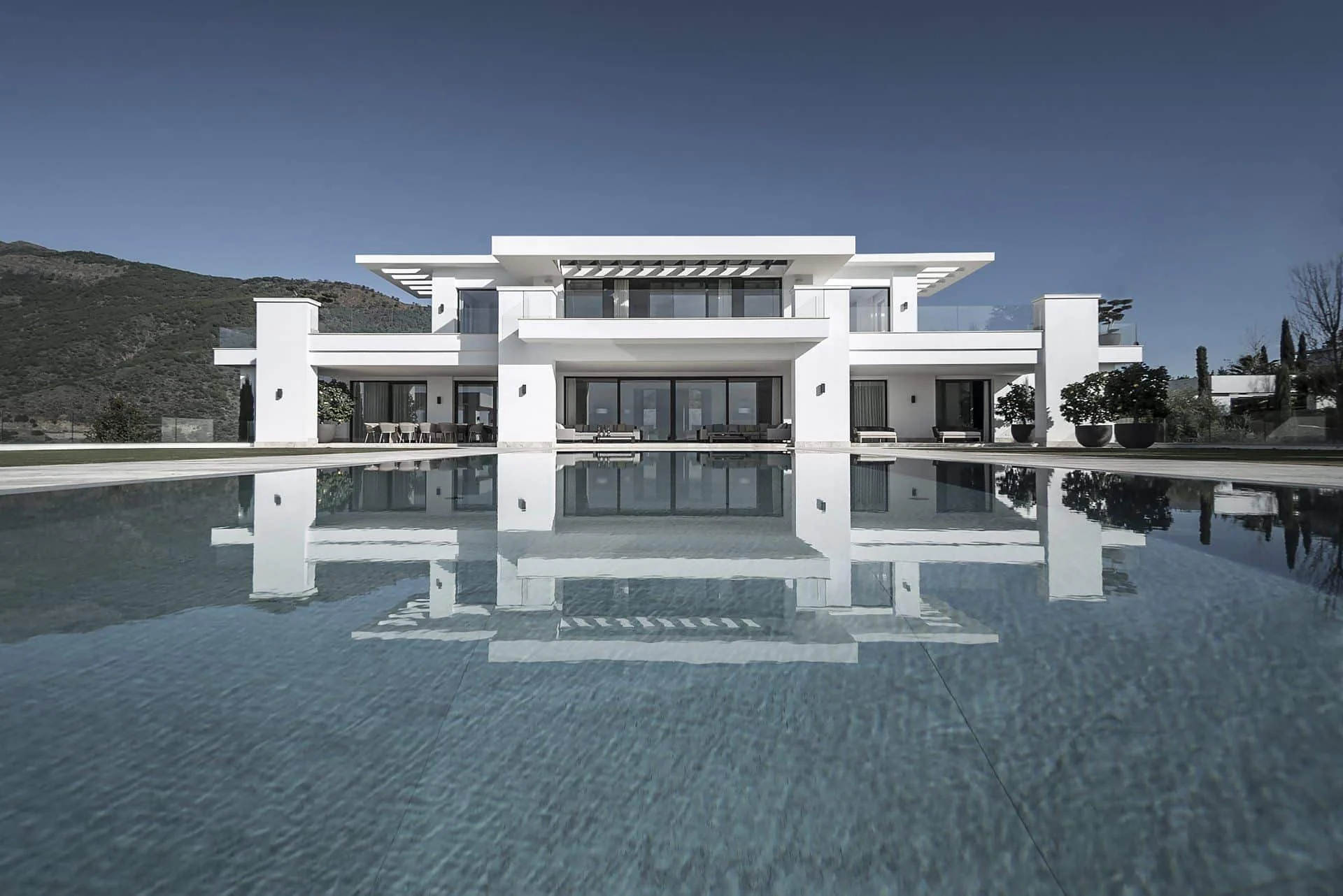 Modern architectural volumes and white facade of a luxury residence in the exclusive La Zagaleta estate.