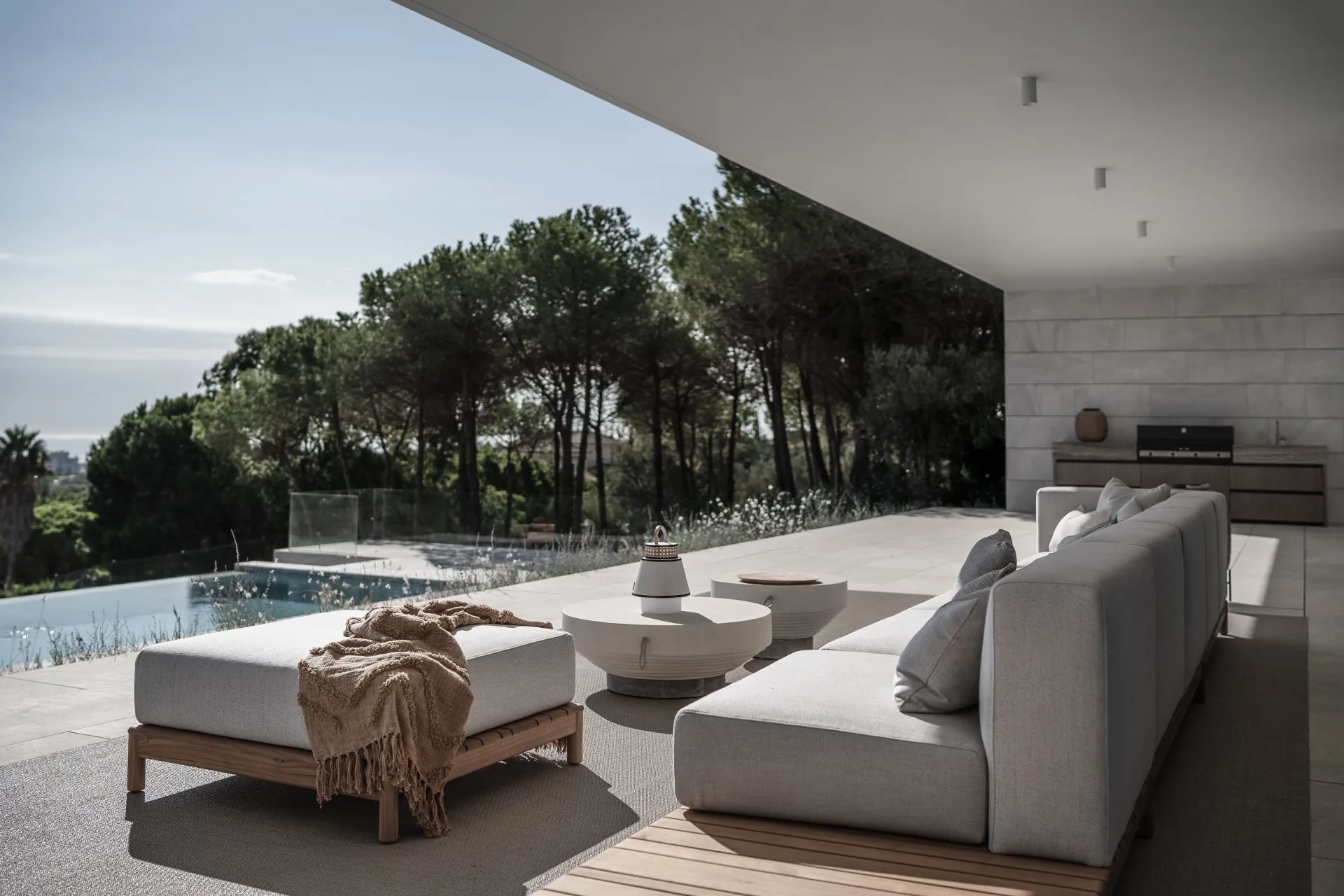 Luxury terrace with comfortable outdoor seating overlooking a Mediterranean pine forest.