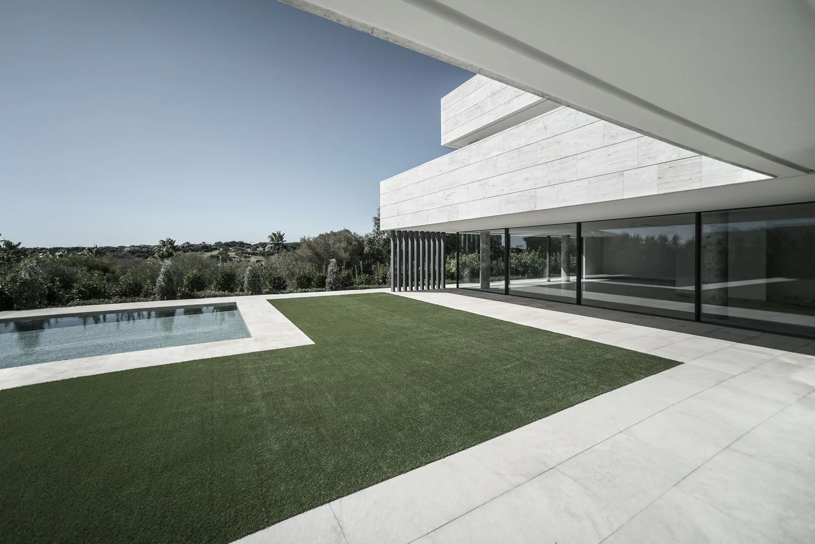 Covered terrace of Villa Logika, architecture of light opening to pool and landscape