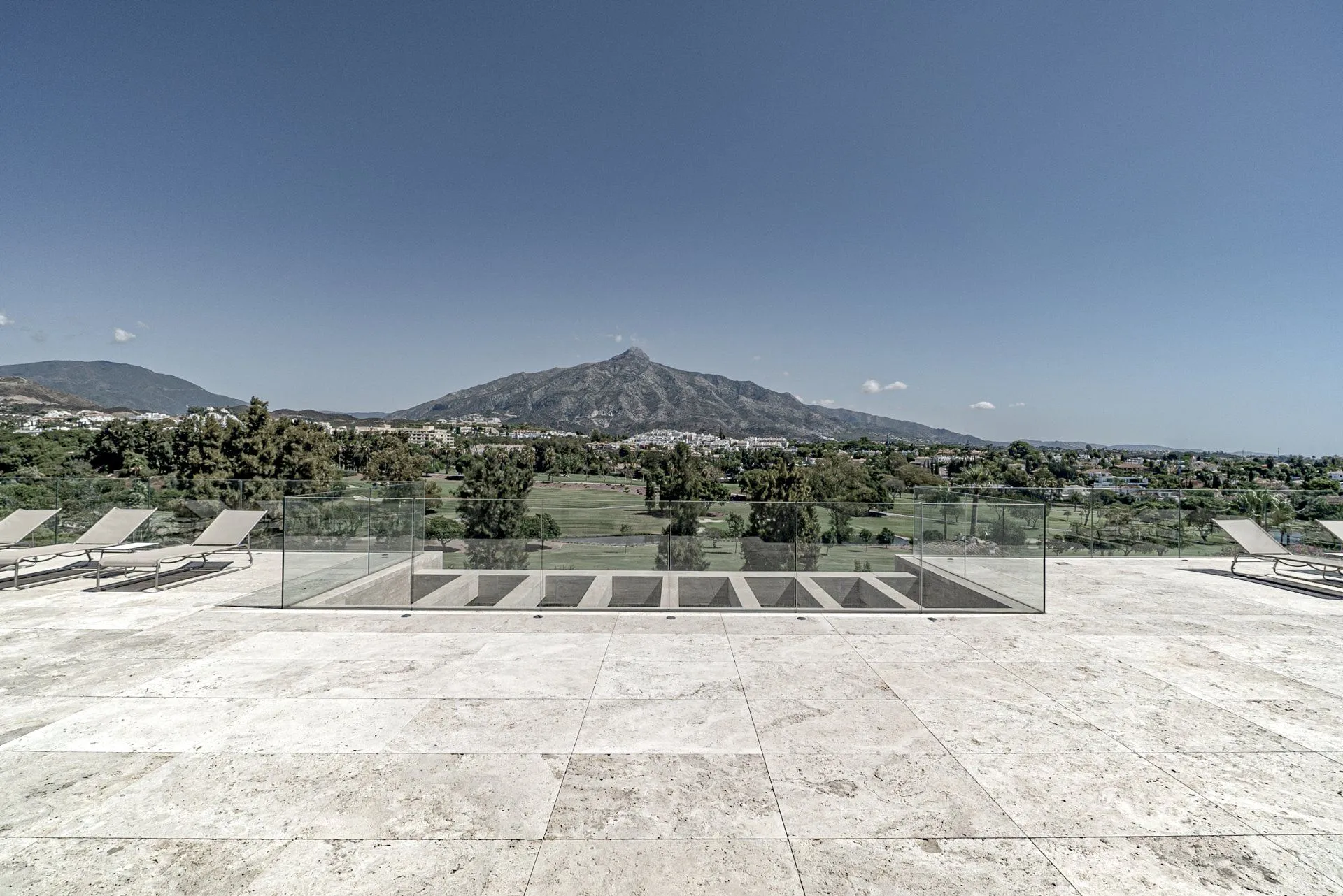Minimalist outdoor patio featuring high-end natural stone flooring and seamless indoor-outdoor flow.