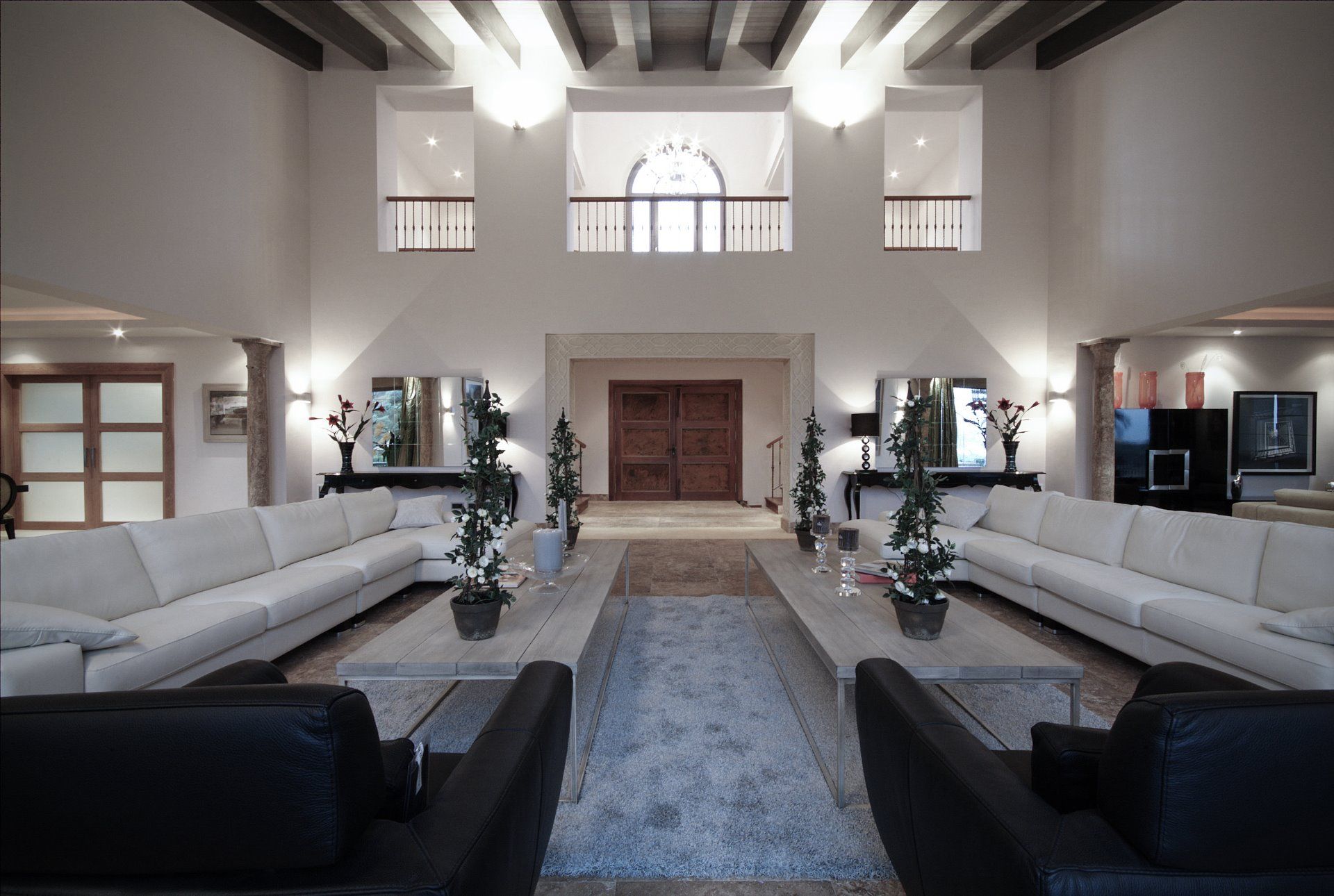 Double-height grand entrance hall designed by ARK Architects using natural stone and symmetrical minimalist lines.