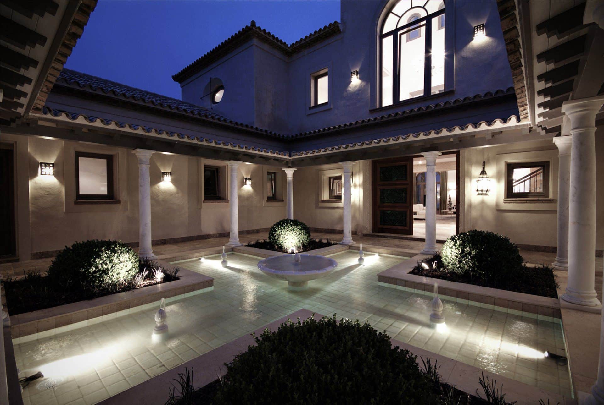 Night view of a luxury infinity pool with sophisticated outdoor lighting reflecting the bespoke architecture.