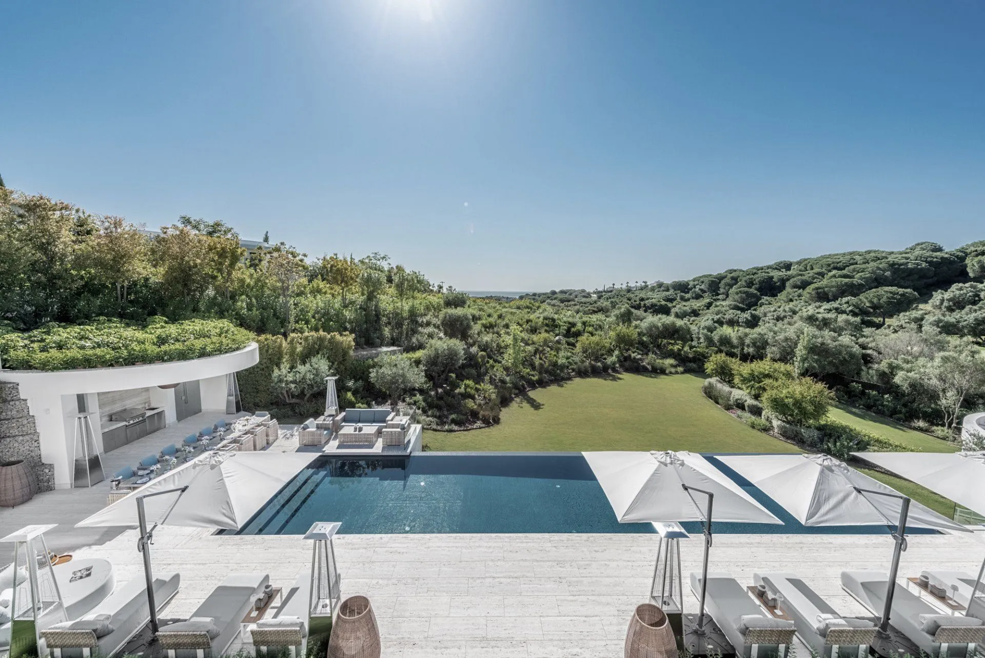 Seamless indoor-outdoor flow at the infinity pool terrace with panoramic views of the Sotogrande landscape.