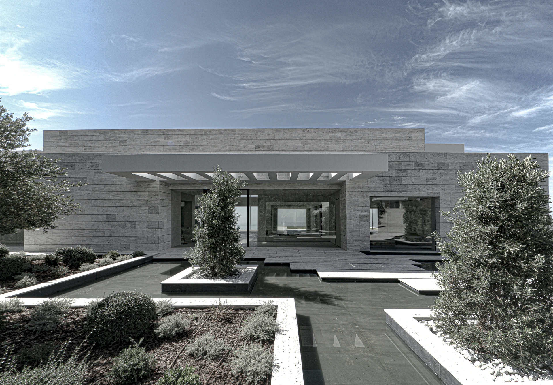 Minimalist courtyard with stone flooring and integrated greenery in a high-end residence.