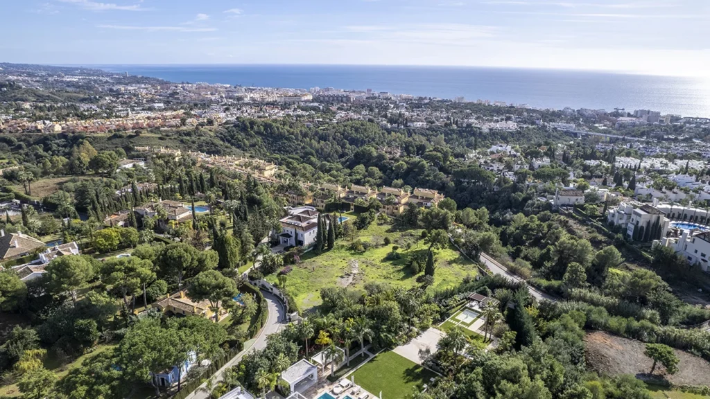 Aerial perspective of a luxury residential plot in Cascada de Camoján, Marbella, featuring Mediterranean landscape and sea views.