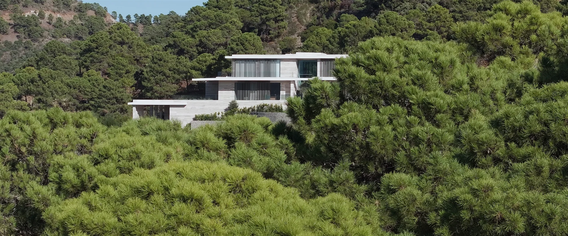 Architectural shot of Villa Geneve highlighting its perfect balance with the surrounding Mediterranean forest.
