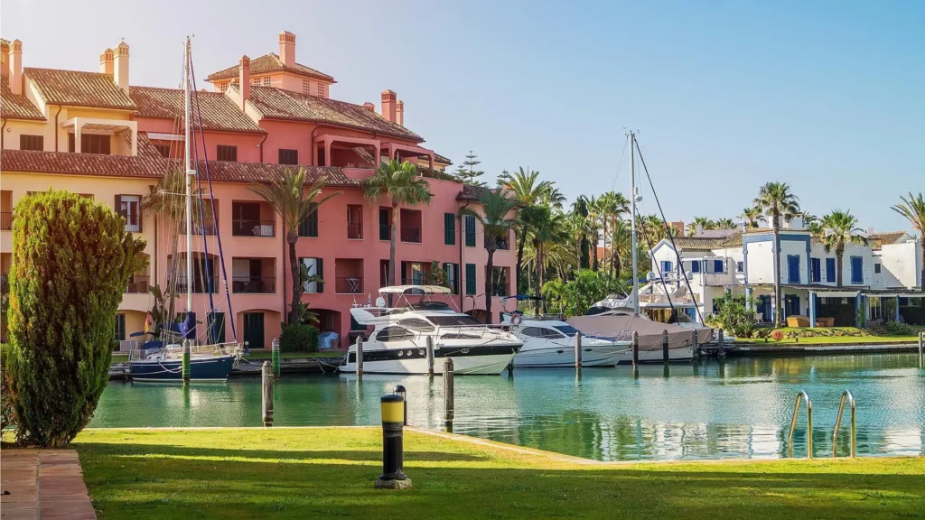 luxury yachts in sotogrande marina next to colorful waterfront apartments