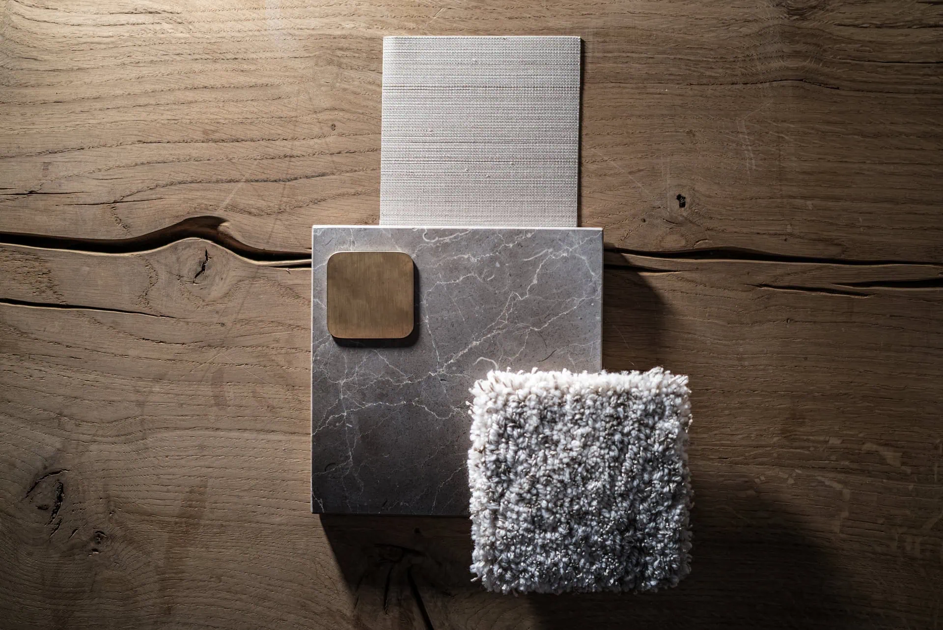 Array of natural stone, wood, marble, and fabric samples on wooden surface, showcasing ARK Architects' material palette for contextual designs