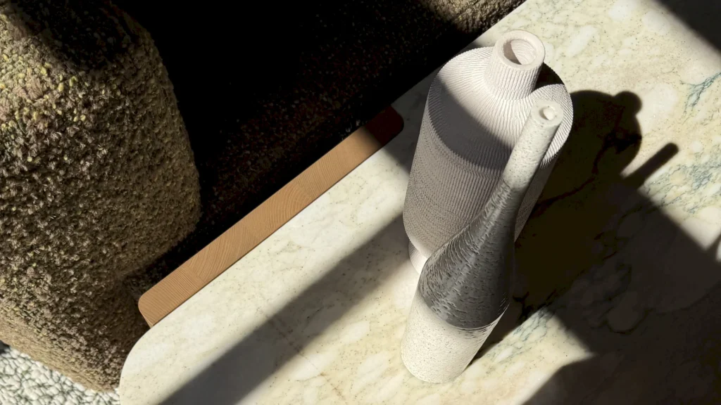 A decorative detail featuring textured ceramic vases set against a high-quality marble surface, enhanced by the play of light.