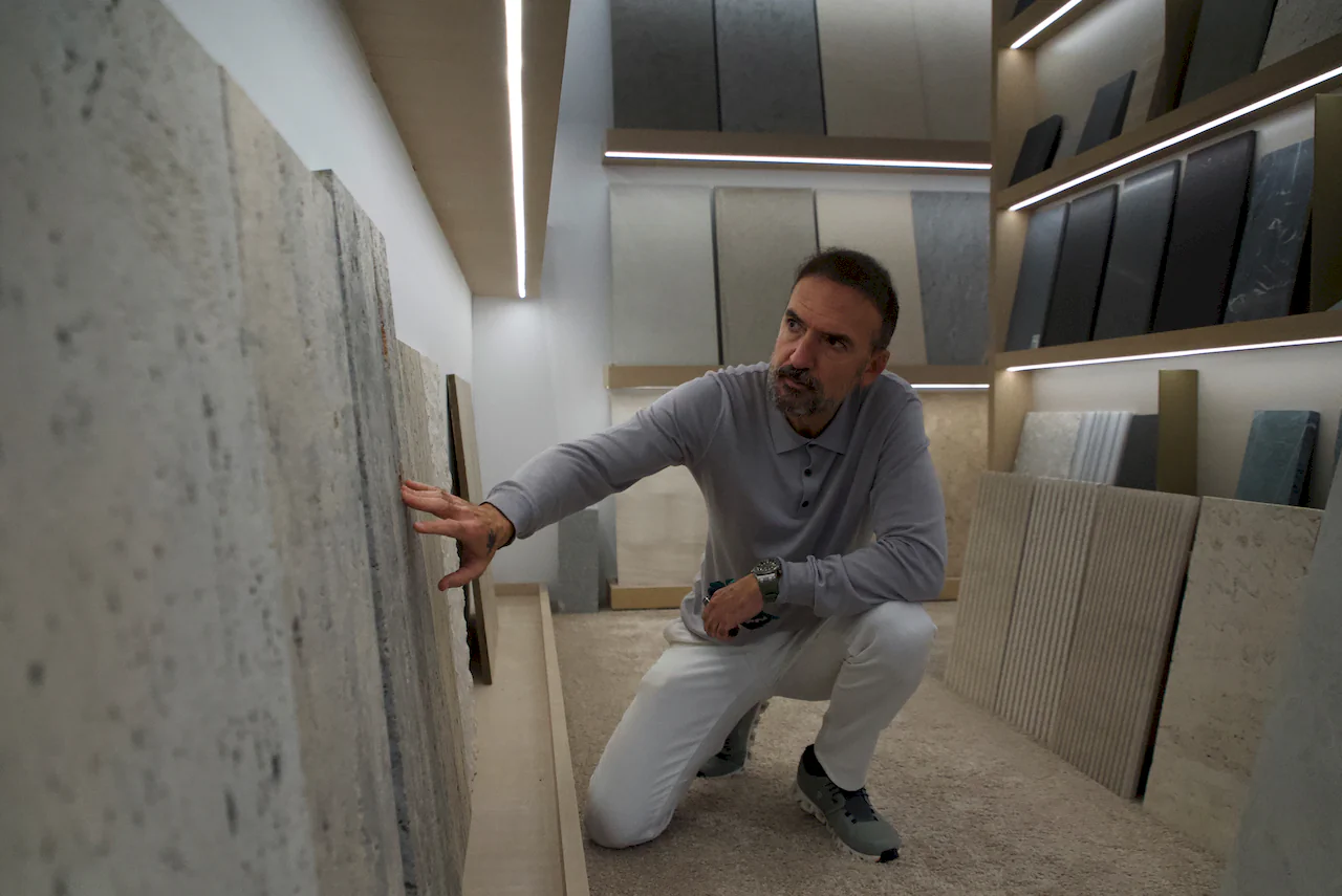 El arquitecto Manuel Ruiz Moriche analizando texturas y materiales pétreos naturales en una exposición de diseño.