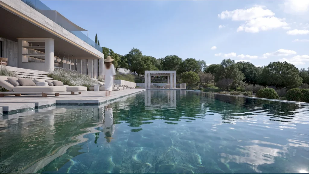 A woman in a white dress and hat walks beside a modern outdoor swimming pool, surrounded by lounge chairs, greenery, and a contemporary villa under a blue sky.