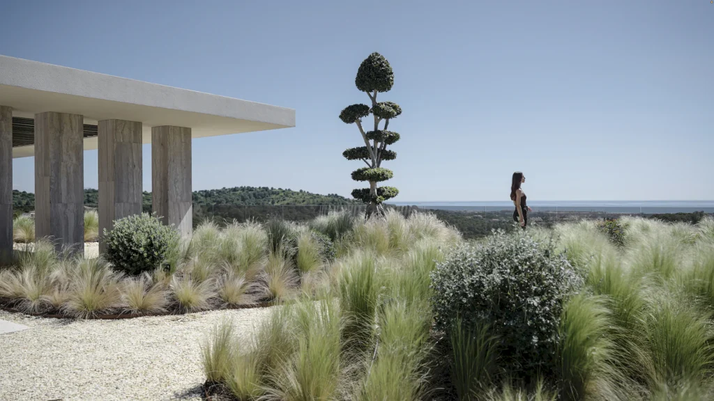 Mujer caminando por el jardín minimalista de Villa Enso con vistas al mar y arquitectura de autor en Sotogrande.